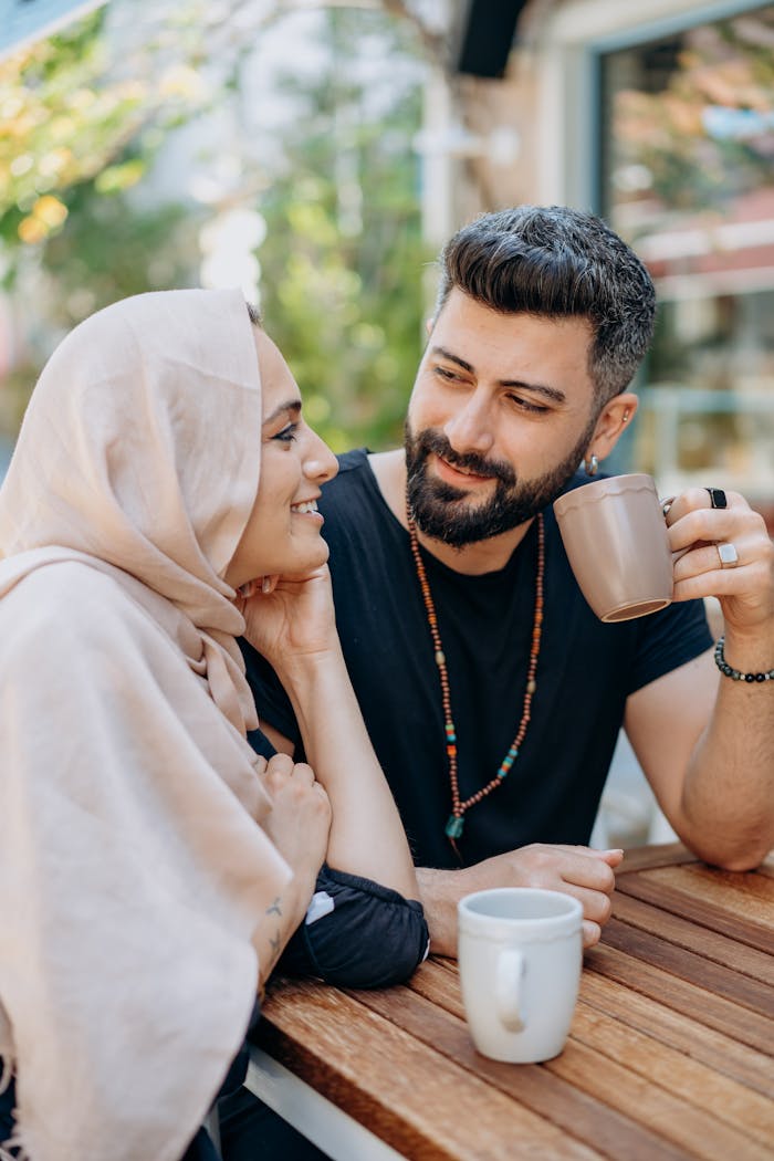 gallery-3 A loving couple shares a cozy moment with coffee outdoors, smiling and enjoying the day.